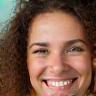 Jonge vrouw met krullen, glimlacht